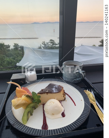 Enjoy a dessert plate and sunset view at a cafe overlooking the sea. Enjoy a dessert plate and sunset view at a cafe overlooking the sea. 140241163