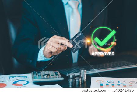 Businessman holding credit card with green approved check mark icon on virtual screen. Successful online payment transaction concept. Businessman holding credit card with green approved check mark icon on virtual screen. Successful online payment transaction concept. 140241459