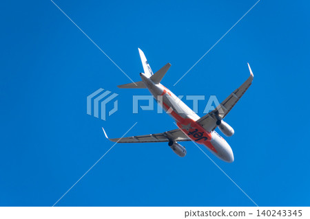 Image of a passenger plane flying through a blue sky - Jetstar Image of a passenger plane flying through a blue sky - Jetstar 140243345