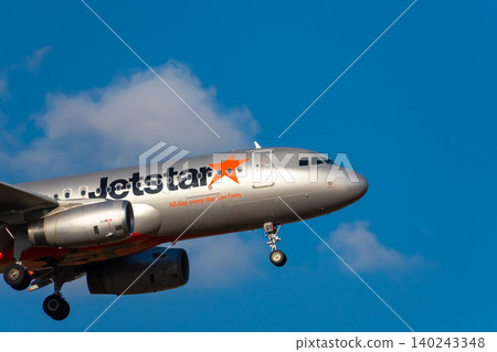 Image of a passenger plane flying through a blue sky - Jetstar Image of a passenger plane flying through a blue sky - Jetstar 140243348