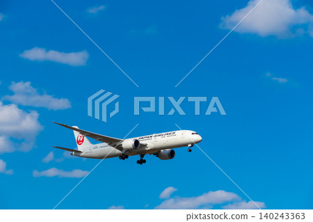 Image of a passenger plane flying through a blue sky - Japan Airlines Image of a passenger plane flying through a blue sky - Japan Airlines 140243363