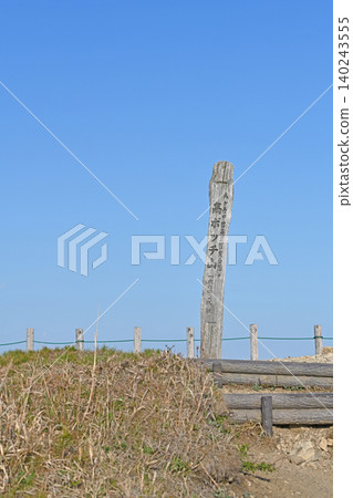 The summit marker of Mt. Takabocchi: A wooden monument standing out against the blue sky, and the summit of the Yatsugatake Chushin Kogen Quasi-National Park. 140243555