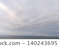 A tranquil seascape where the warm glow of the horizon harmonizes with soft clouds. 140243695