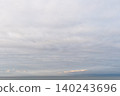 A calm sea with soft clouds and a warm, pastel horizon. 140243696