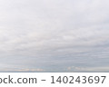 A cloudy sky with a faint pink light lingering on the horizon, and a tranquil landscape. 140243697