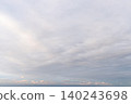 A fantastical seascape woven from the lingering glow of pale pink and gentle layers of clouds. 140243698