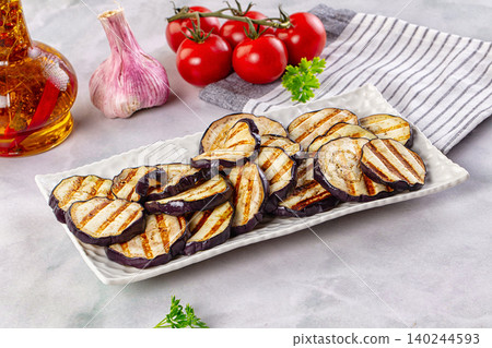Grilled eggplant slices on white plate with tomatoes and garlic Grilled eggplant slices on white plate with tomatoes and garlic 140244593