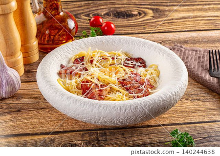 Spaghetti carbonara with crispy bacon and parmesan cheese in white bowl 140244638