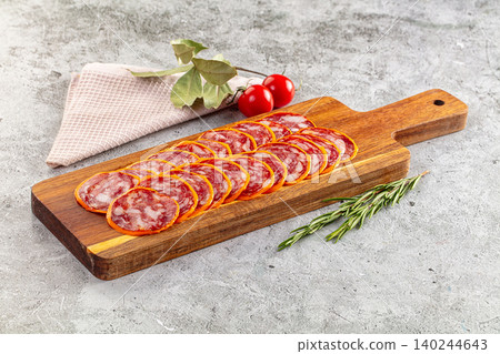 Cured sausage slices, fresh rosemary, cherry tomatoes on cutting board 140244643
