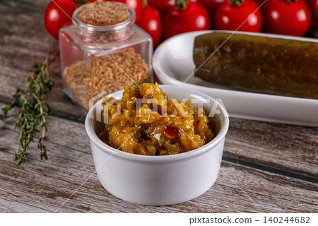 Yellow relish in white bowl with pickled cucumber and mustard seeds Yellow relish in white bowl with pickled cucumber and mustard seeds 140244682