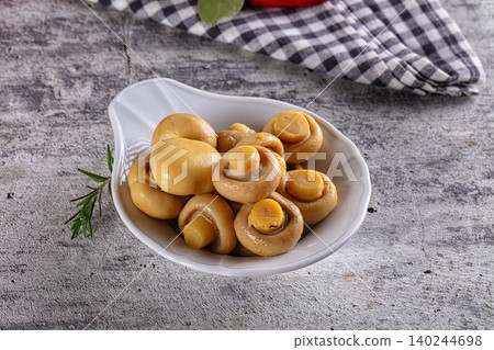 Pickled mushrooms in white bowl on stone table Pickled mushrooms in white bowl on stone table 140244698