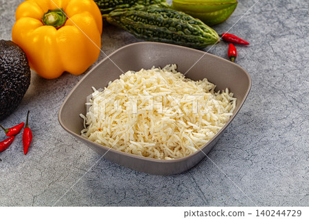 Steamed white rice in bowl with fresh vegetables and peppers on gray stone background Steamed white rice in bowl with fresh vegetables and peppers on gray stone background 140244729