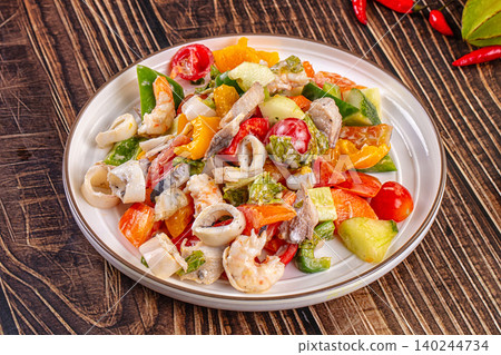 Seafood salad with squid rings and shrimp on a white plate 140244734