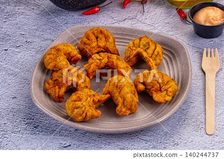 Spicy fried dumplings on grey plate with dipping sauce and chili peppers Spicy fried dumplings on grey plate with dipping sauce and chili peppers 140244737