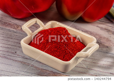Red Paprika Powder in Ceramic Dish with Fresh Bell Peppers Red Paprika Powder in Ceramic Dish with Fresh Bell Peppers 140244794