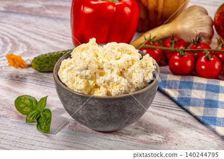 Fresh cottage cheese in bowl with vegetables on wooden table Fresh cottage cheese in bowl with vegetables on wooden table 140244795