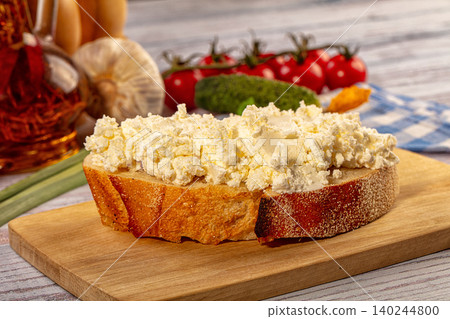 Fresh cottage cheese spread on rustic bread slice with vegetables Fresh cottage cheese spread on rustic bread slice with vegetables 140244800