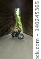 Motorcycle emerging from tunnel 140245365