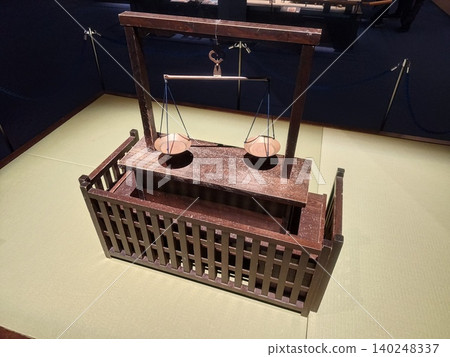 A museum exhibiting a wooden balance scale model. A museum exhibiting a wooden balance scale model. 140248337