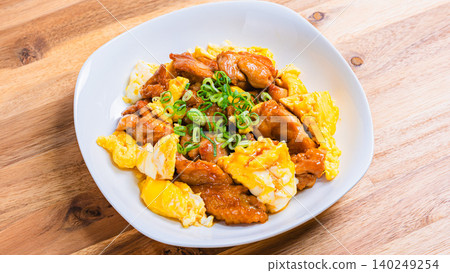 A photo of a Japanese-style dish of teriyaki chicken and egg stir-fried in a sweet and savory sauce. 140249254