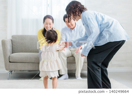 A three-generation family: Mother and grandparents playing with their child in the living room. A three-generation family: Mother and grandparents playing with their child in the living room. 140249664
