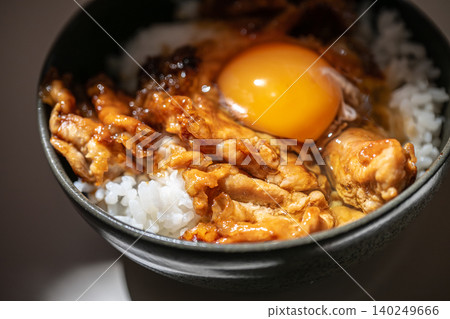 特寫鏡頭:一碗豬肉飯,上面放著一個蛋黃。 特寫鏡頭:一碗豬肉飯,上面放著一個蛋黃。 140249666