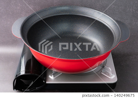 A red pot placed on a portable gas stove A red pot placed on a portable gas stove 140249675