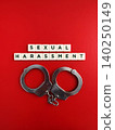 Handcuffs and sexual harassment scrabble tiles on red background 140250149
