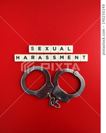 Handcuffs and sexual harassment scrabble tiles on red background 140250149