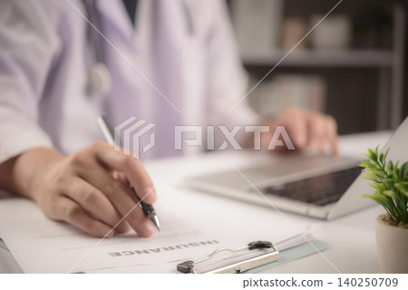 Doctor signing health insurance contract form on clipboard. Medical healthcare concept showing physician filling out policy document, claim paperwork, and agreement on office desk. Doctor signing health insurance contract form on clipboard. Medical healthcare concept showing physician filling out policy document, claim paperwork, and agreement on office desk. 140250709