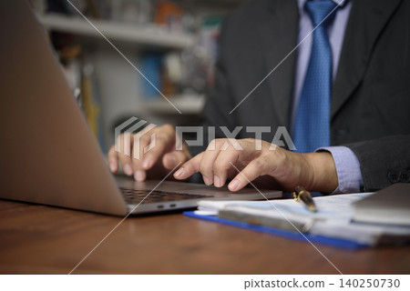 Close up businessman hands typing on laptop keyboard. Professional executive manager working on business project, sending email, and using internet technology in corporate office. Close up businessman hands typing on laptop keyboard. Professional executive manager working on business project, sending email, and using internet technology in corporate office. 140250730