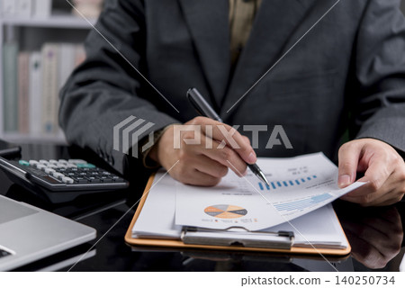 Close up businessman hand analyzing financial report data with calculator. Professional accountant working on investment strategy, corporate tax, market chart audit and business planning in office. Close up businessman hand analyzing financial report data with calculator. Professional accountant working on investment strategy, corporate tax, market chart audit and business planning in office. 140250734