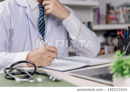 Doctor, healthcare Physician writes notebook at clinic office hospital document patient record, plan diagnosis and treatment, stethoscope and laptop, accurate medical paperwork and care quality. Doctor, healthcare Physician writes notebook at clinic office hospital document patient record, plan diagnosis and treatment, stethoscope and laptop, accurate medical paperwork and care quality. 140251024