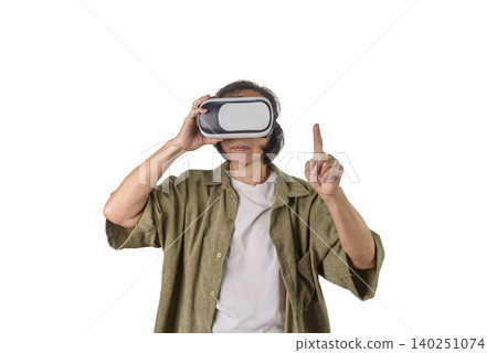 Senior Asian woman wearing VR headset pointing finger touching virtual interface screen on white background. Elderly technology lifestyle, metaverse gaming experience, and digital control concept. Senior Asian woman wearing VR headset pointing finger touching virtual interface screen on white background. Elderly technology lifestyle, metaverse gaming experience, and digital control concept. 140251074