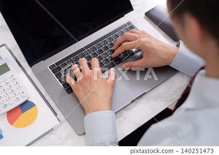 A man using a computer at a simple desk. A man using a computer at a simple desk. 140251473