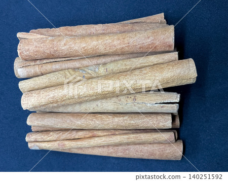 Row of aromatic dried cinnamon bark sticks spice dalchini Row of aromatic dried cinnamon bark sticks spice dalchini 140251592