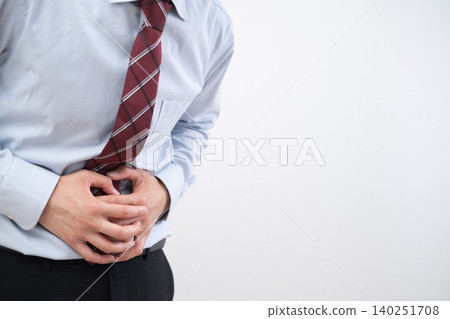 A businessman clutches his stomach due to abdominal pain. A businessman clutches his stomach due to abdominal pain. 140251708