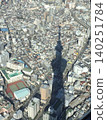 The shadow of a gigantic tower stretches across the diorama-like cityscape of Tokyo. 140251784