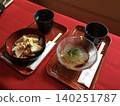 Japanese sweets and tea (kuzumochi, tokoroten) are arranged on a red felt mat. 140251787