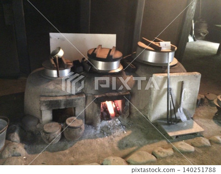 A reproduction of a traditional cultural property house, featuring a scene of a hearth with a fire burning. A reproduction of a traditional cultural property house, featuring a scene of a hearth with a fire burning. 140251788