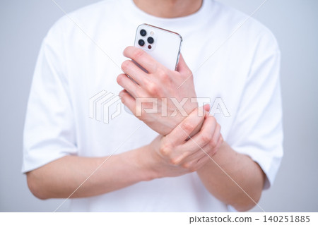 一名男子拿著智能手機，手腕疼痛 140251885
