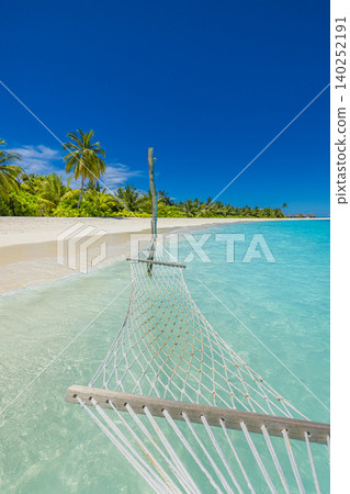 Vertical view of a beach hammock framed by towering palms. Crystal Maldives shallows stretching toward the horizon. Portrait orientation perfect for mobile screens. Serene tropical escape moody Vertical view of a beach hammock framed by towering palms. Crystal Maldives shallows stretching toward the horizon. Portrait orientation perfect for mobile screens. Serene tropical escape moody 140252191