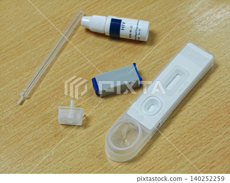 HIV Self Testing Kit on Wooden Table plastic white blue clear pipette health medical diagnosis disease HIV Self Testing Kit on Wooden Table plastic white blue clear pipette health medical diagnosis disease 140252259