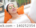 Beauty young asian woman relax on sofa with cucumber eye mask in living room. 140252354