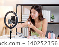 Young asian woman presenting and review cosmetic product with excitement on social media. 140252356