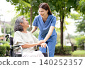 Young caucasian nurse comforting with patient while sitting on wheelchair in outdoor park. 140252357