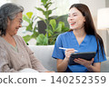 Asian woman caregiver using digital tablet for senior patient consultation. 140252359