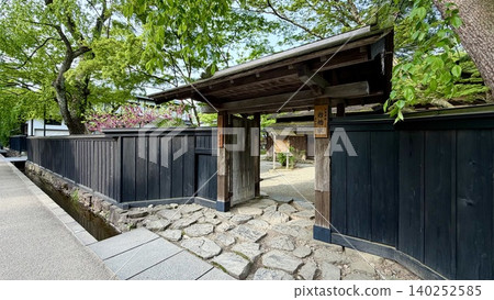 街道兩旁林立著藥屋門和黑色木柵欄,五月的晴空萬裡,樹木蔥鬱鬱蔥蔥。 (武士宅邸街/秋田縣仙北市角館町) 街道兩旁林立著藥屋門和黑色木柵欄,五月的晴空萬裡,樹木蔥鬱鬱蔥蔥。 (武士宅邸街/秋田縣仙北市角館町) 140252585