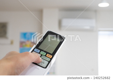 Hand to operate the remote control of the air conditioner Hand to operate the remote control of the air conditioner 140252682