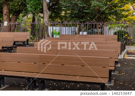 Numerous wooden benches neatly lined up in the small music hall of Hibiya Park, November 2023. Numerous wooden benches neatly lined up in the small music hall of Hibiya Park, November 2023. 140253047